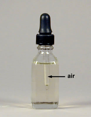 Photograph of a bottle of immersion oil with the dropper 
    filled with air. The air can be easily seen inside the glass dropper. The air has a refractive index of 1.00 while the oil has 
    a refractive index of 1.52.