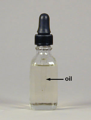 Photograph of a bottle of immersion oil with the dropper 
    filled with immersion oil. The dropper appears to have disappeared. The air has a refractive index of 1.00 while the oil has 
    a refractive index of 1.52.
